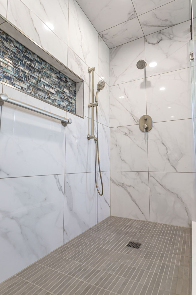 Interior image of a remodeled bathroom with a stand in shower