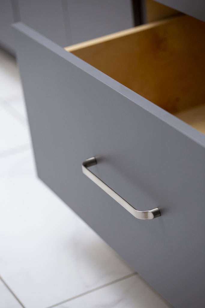 Close up image of a bathroom vanity cabinet with d shaped pull after a bathroom remodel