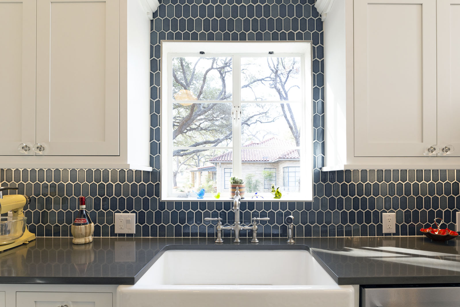 Modern San Antonio kitchen renovation with custom arched range hood and quartz countertops
