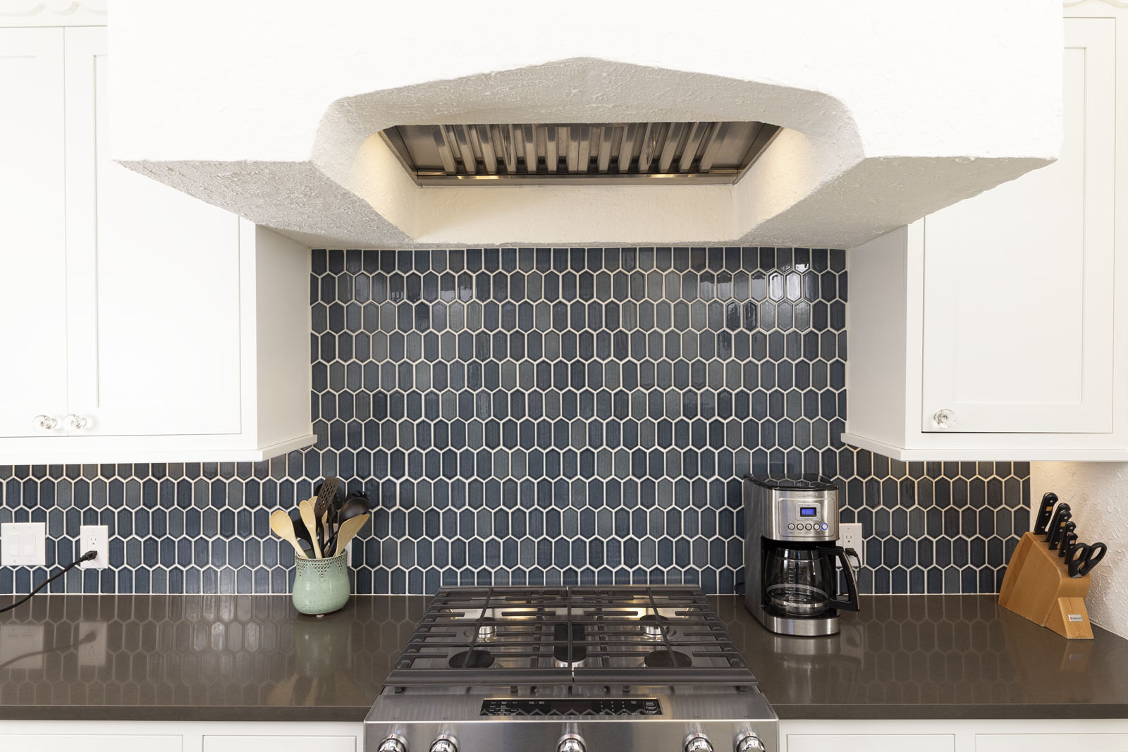 After photo of contemporary kitchen remodel in Monticello Park, San Antonio TX with white cabinets, blue hexagon backsplash and quartz countertops