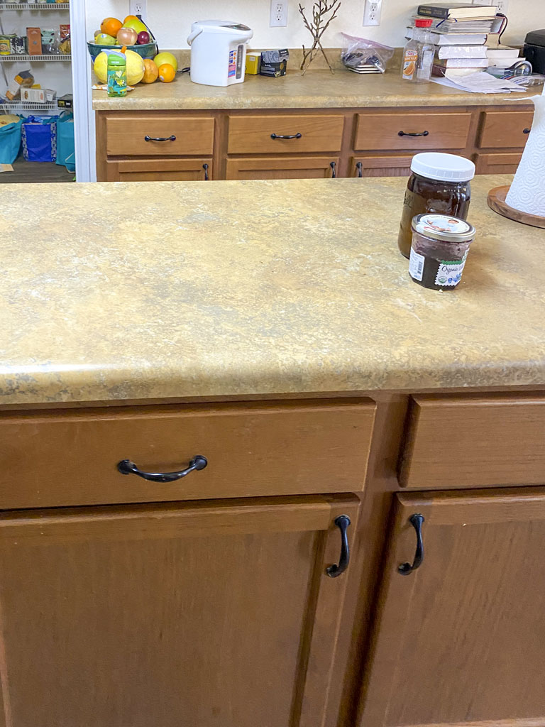 Before kitchen remodel San Antonio with mixed flooring patterns and fluorescent light fixture