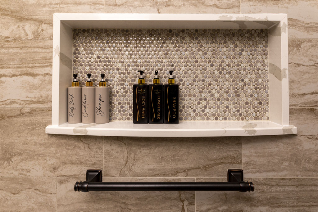 Walk-in shower with Camo Porcelain stone-look tile and quartz-edged shower niche in transitional San Antonio bathroom remodel